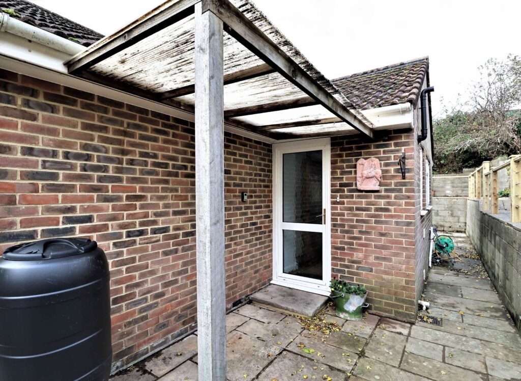 Side lean-to extension with polycarbonate roof on brick bungalow in West Sussex by JT Builds and Specialised Carpentry